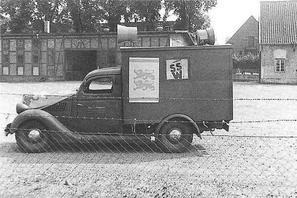 1950er Auto mit SSW Plakat.